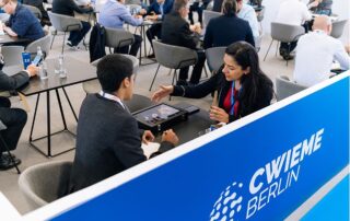 Several occupied tables focusing on two people talking to each other during a CWIEME Berlin Conference.