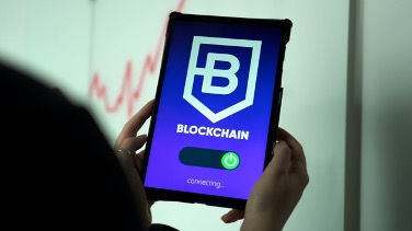 A digital tablet held by a person showing the blockchain webpage connecting.